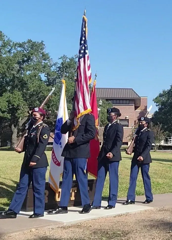 A group of soldiers holding american flags in front of a building