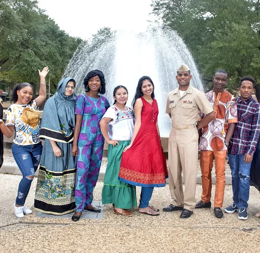 A group of people standing in front of a fountain