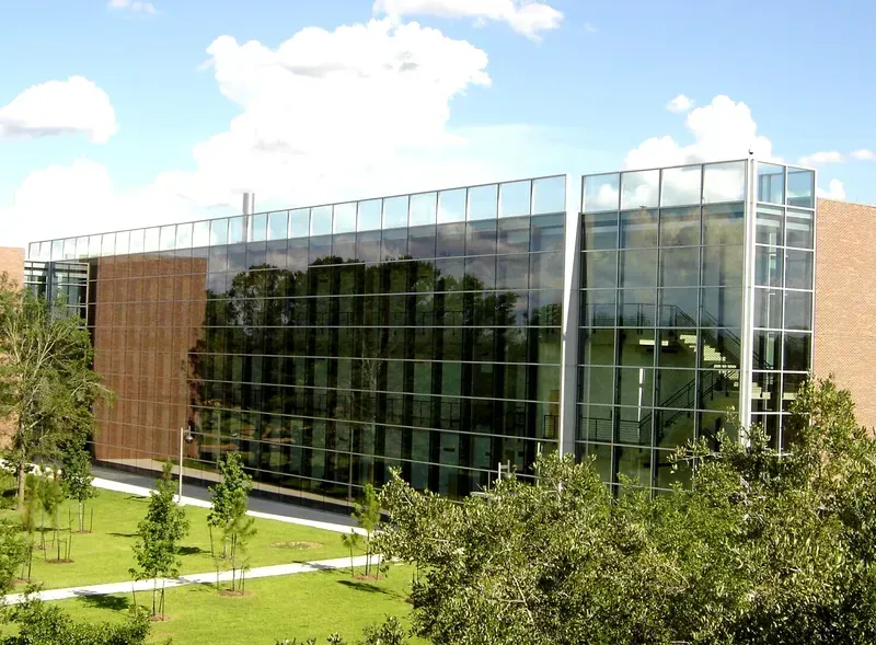 A large building with lots of windows and trees in front of it