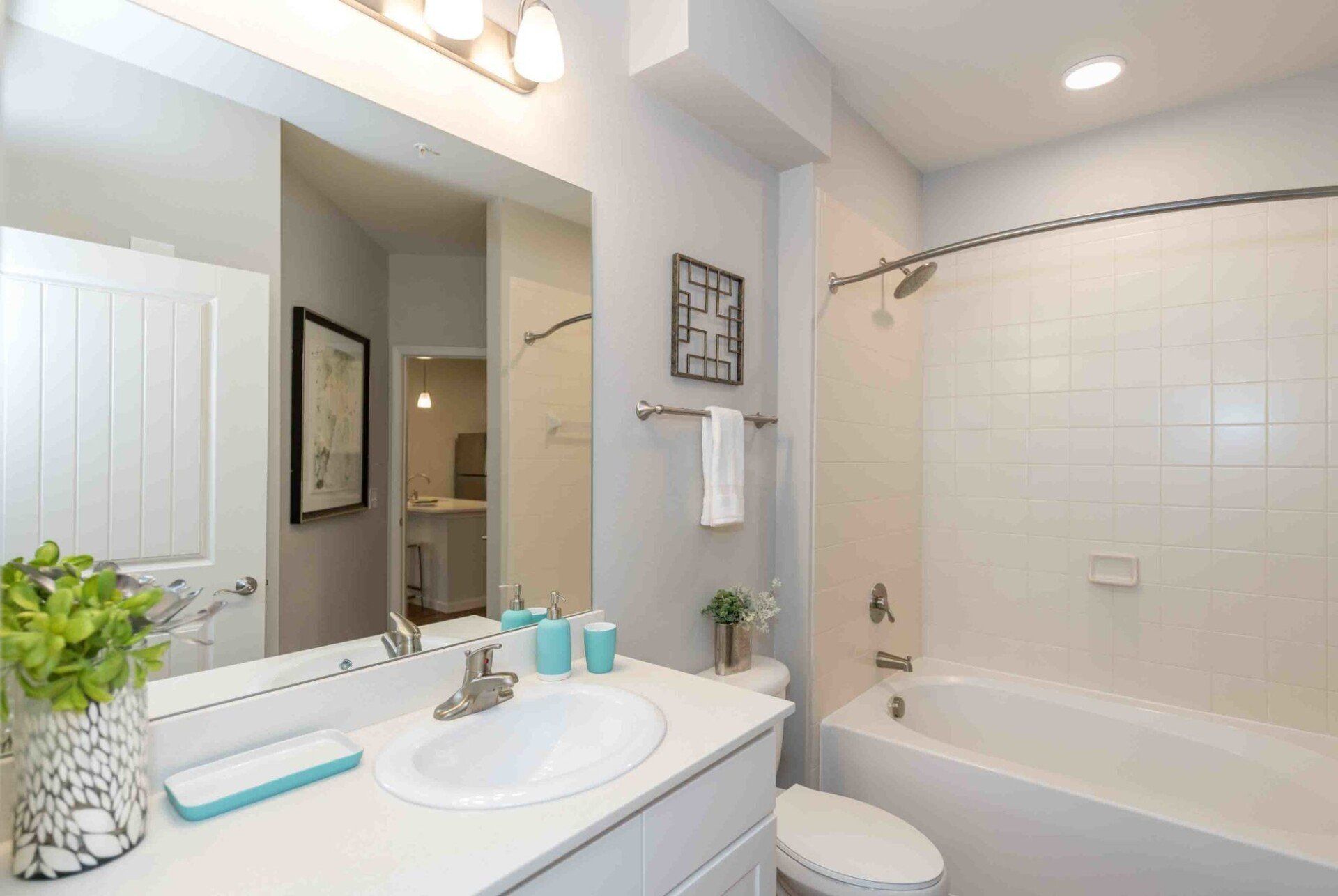 Silver Collection at Celebrate apartment bathroom with oversized mirror, luxury lighting, sink, toilet, and show/bath.