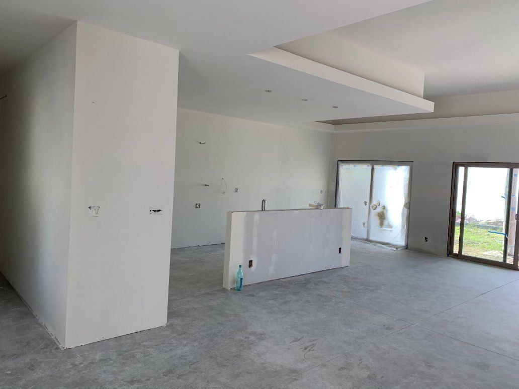 An empty room with white walls and sliding glass doors
