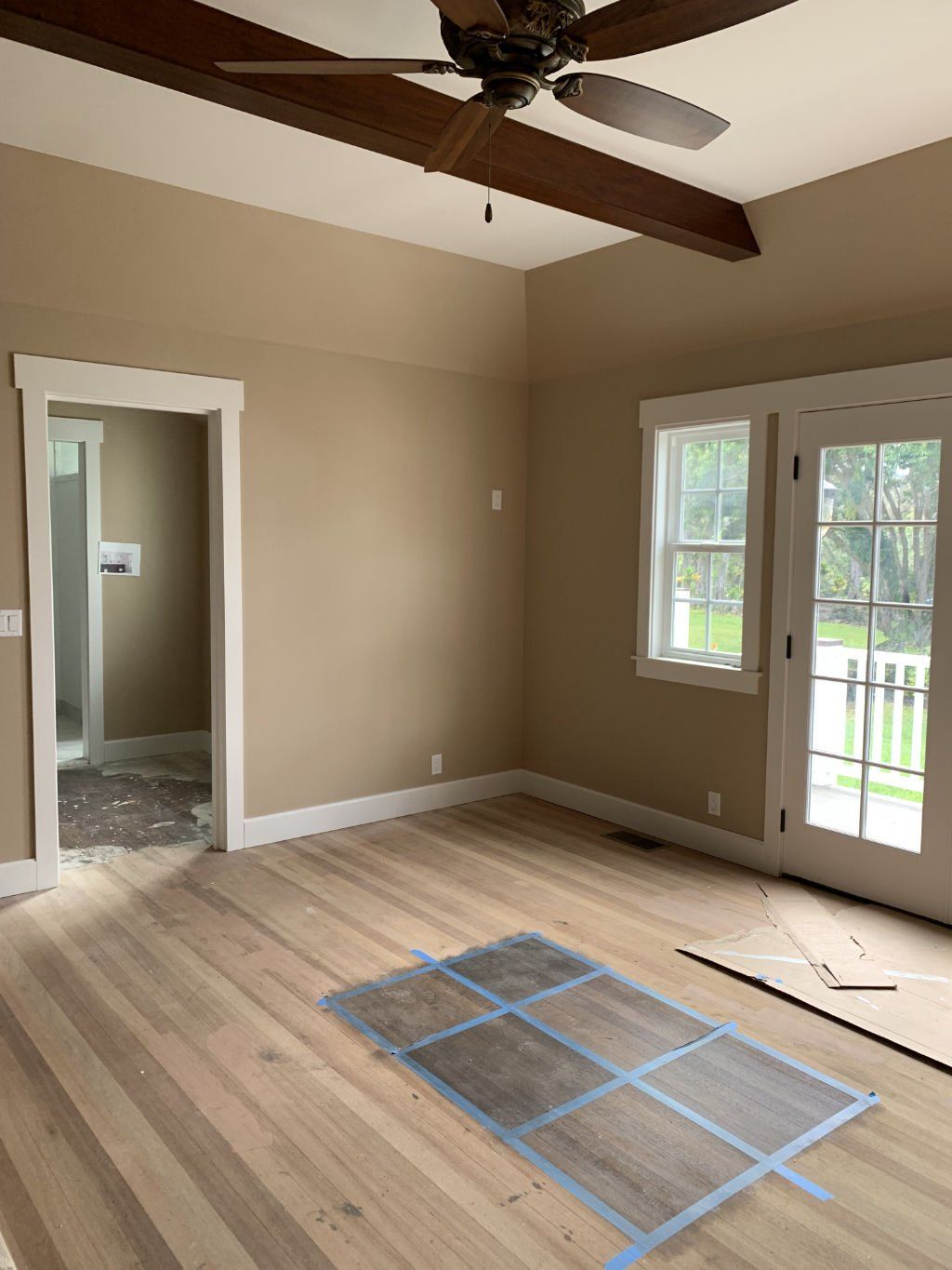 An empty room with hardwood floors and a ceiling fan