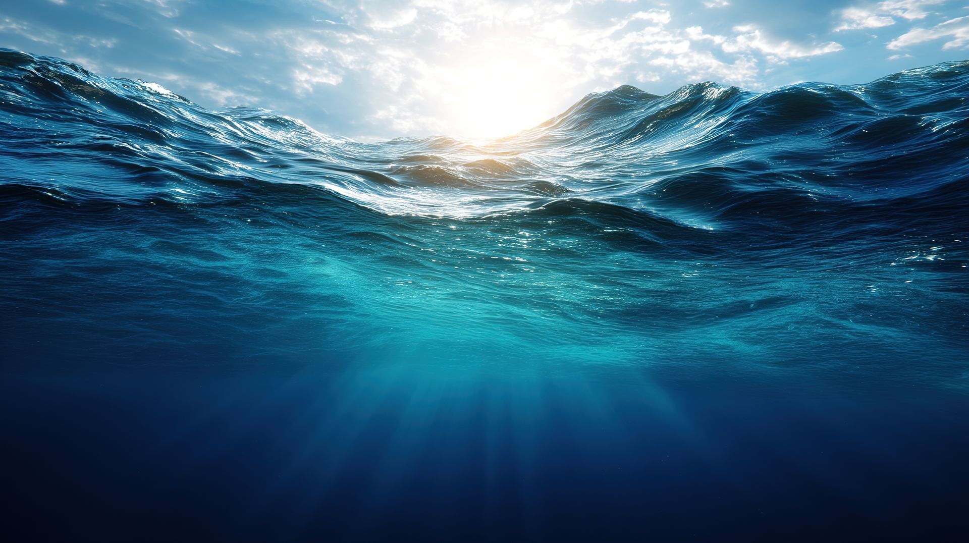 Sunlit ocean waves with blue water and light beams beneath the surface