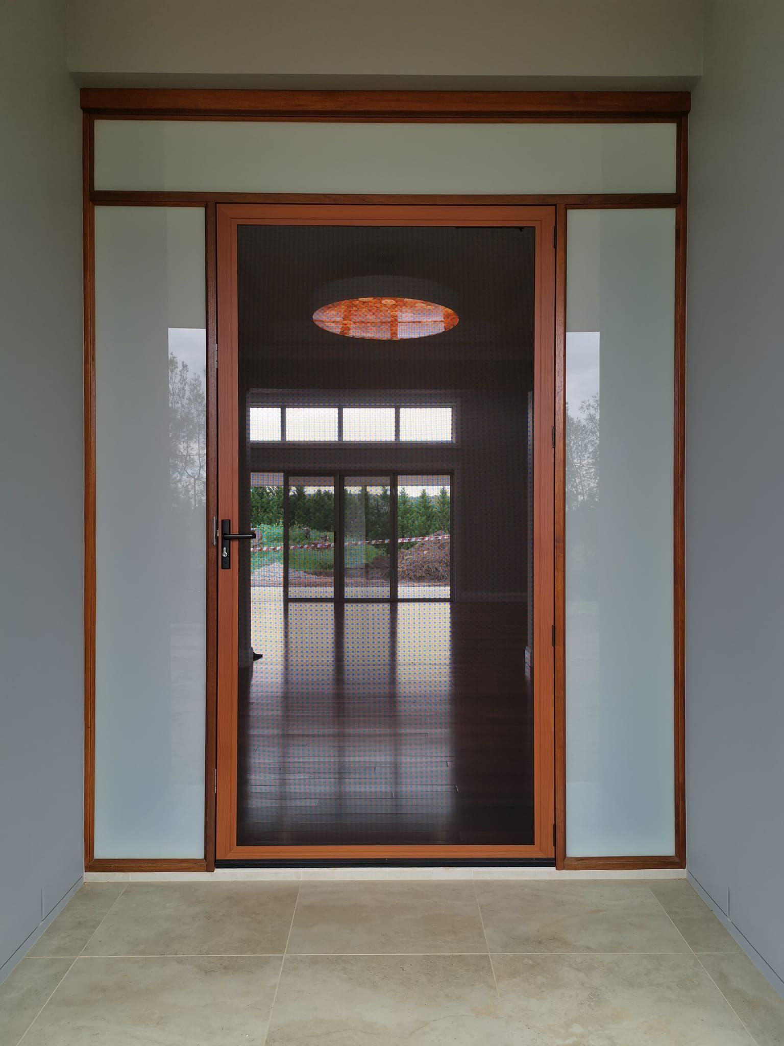 A white door with a screen and two parrots on it
