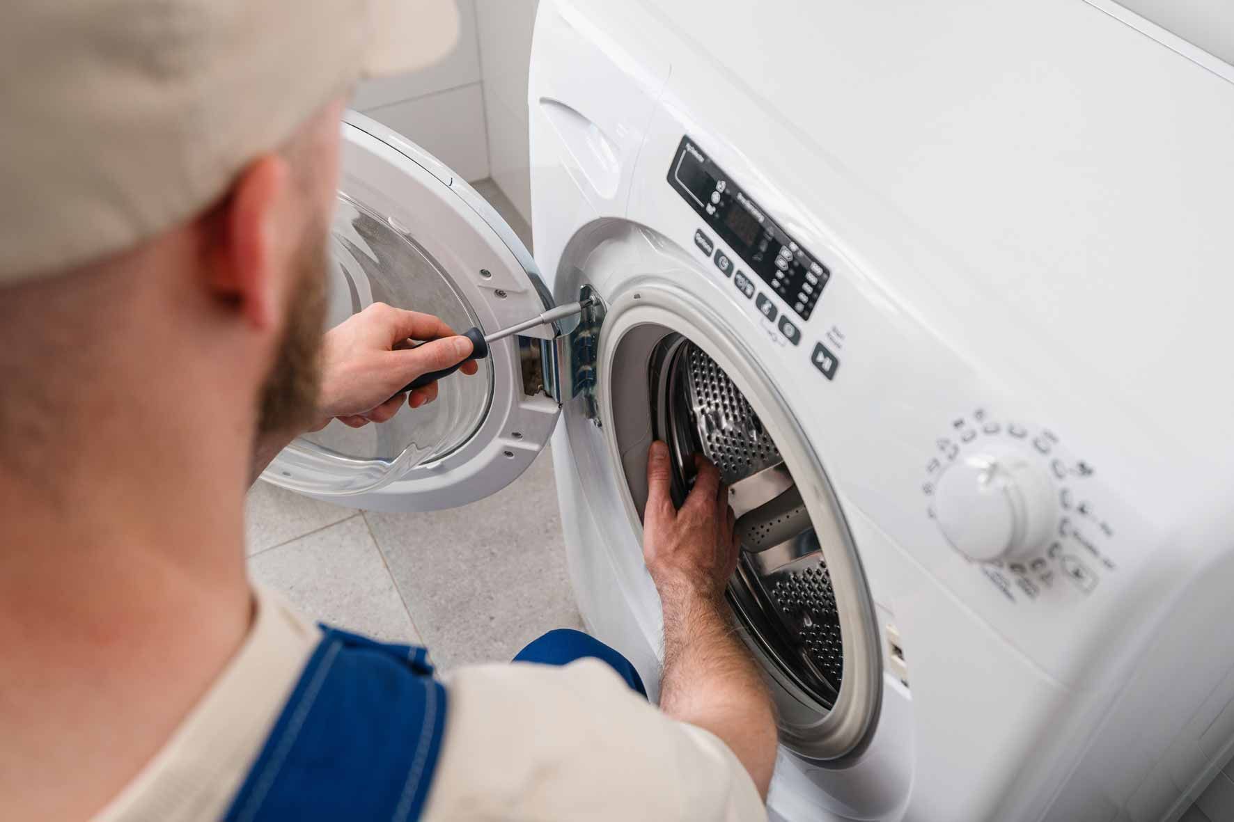 Person loading laundry into a front-loading washing machine