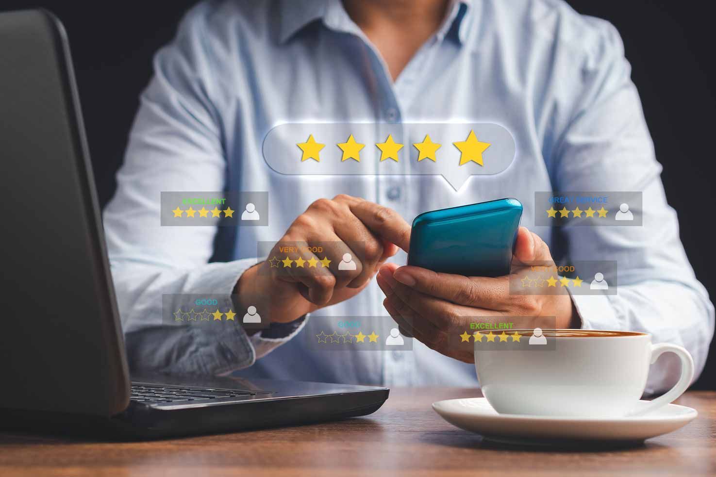 Person using a smartphone beside a laptop and coffee, with star rating icons overlaid on screen