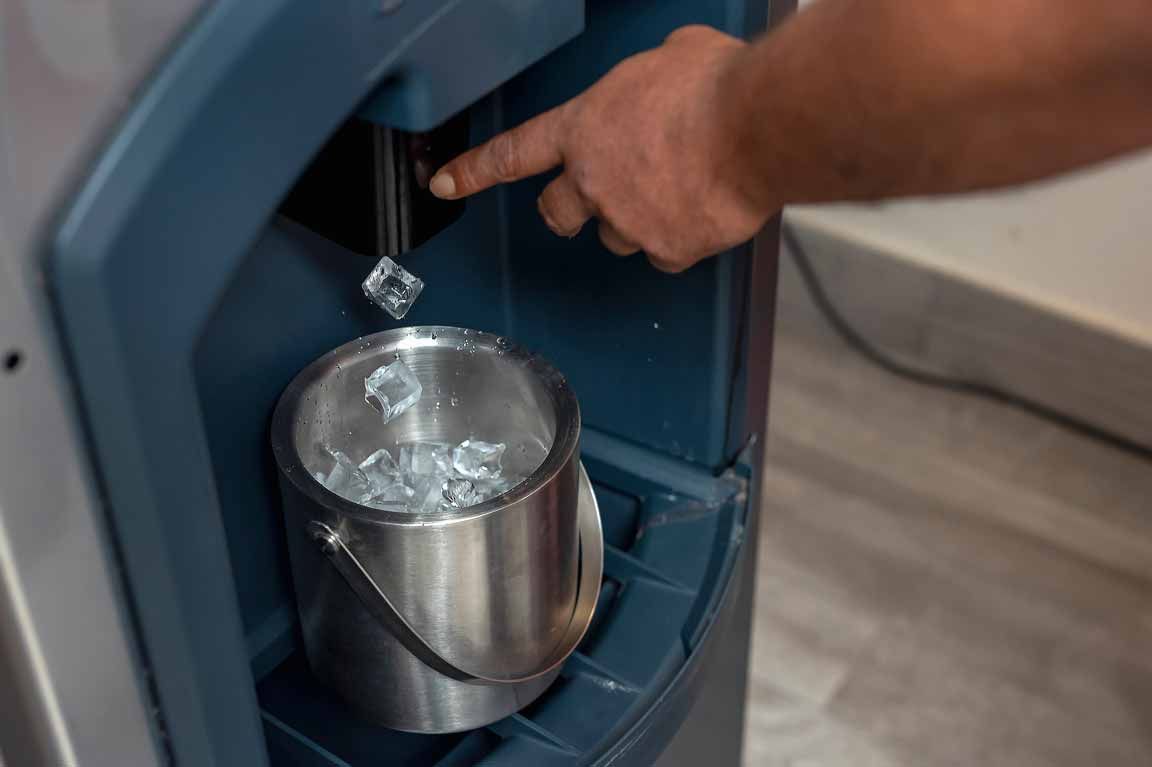 Hand filling a stainless steel cup with water from a blue water cooler