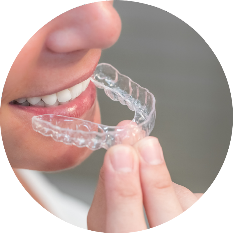 A close up of a person holding a clear mouth guard