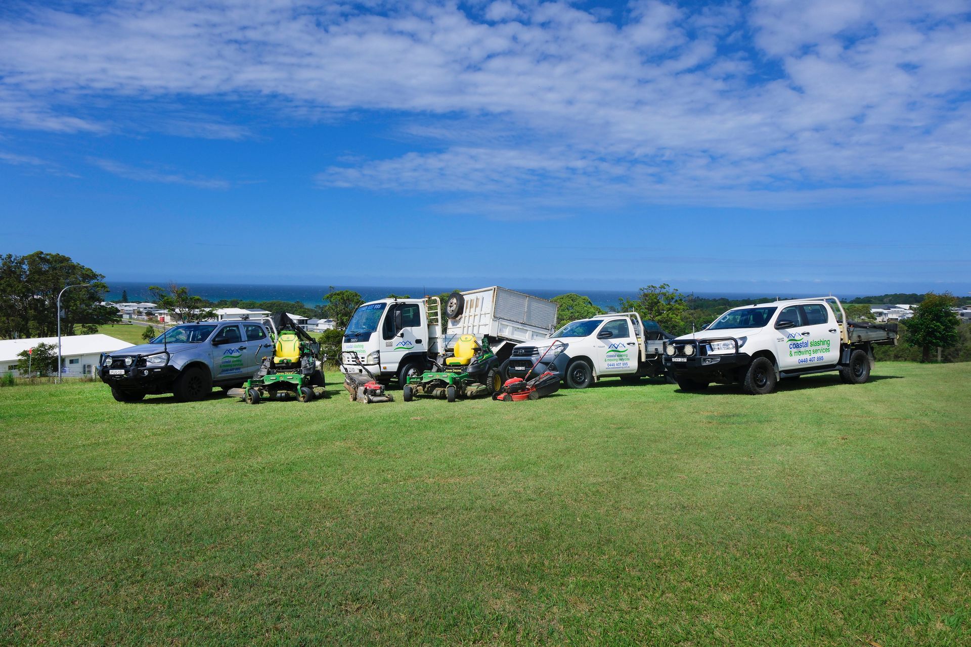 Four Landscaping Vehicles and Equipment Parked on a Grassy — Coastal Slashing & Mowing Services In Taree, NSW