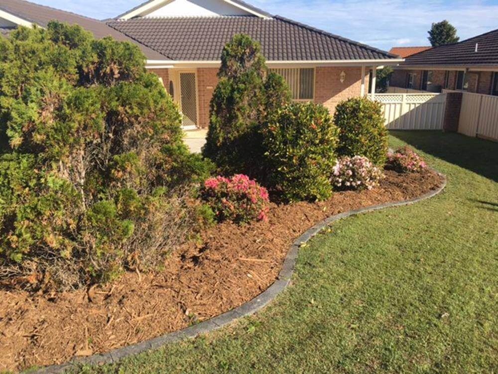 Landscaped Yard With Mulch Beds, Trimmed Bushes and a House — Coastal Slashing & Mowing Services In Old Bar, NSW