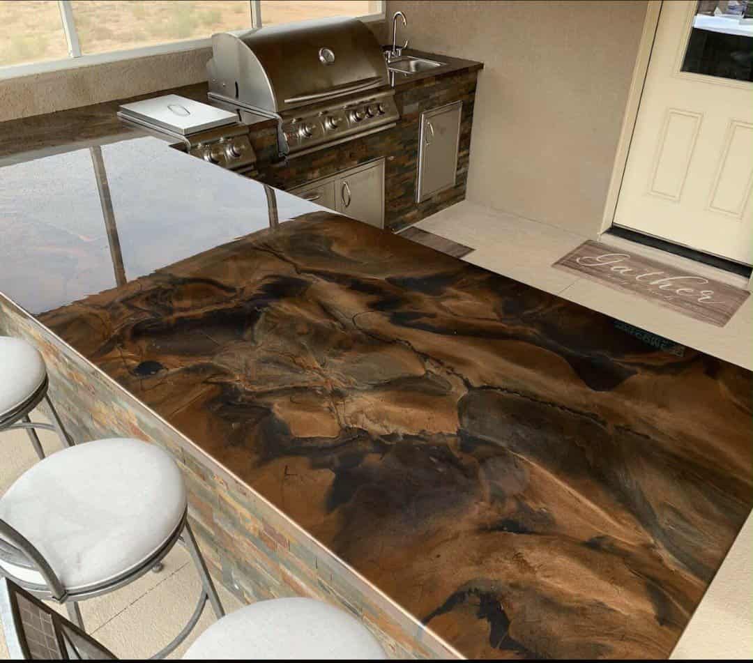 A kitchen with a marble counter top and a grill.