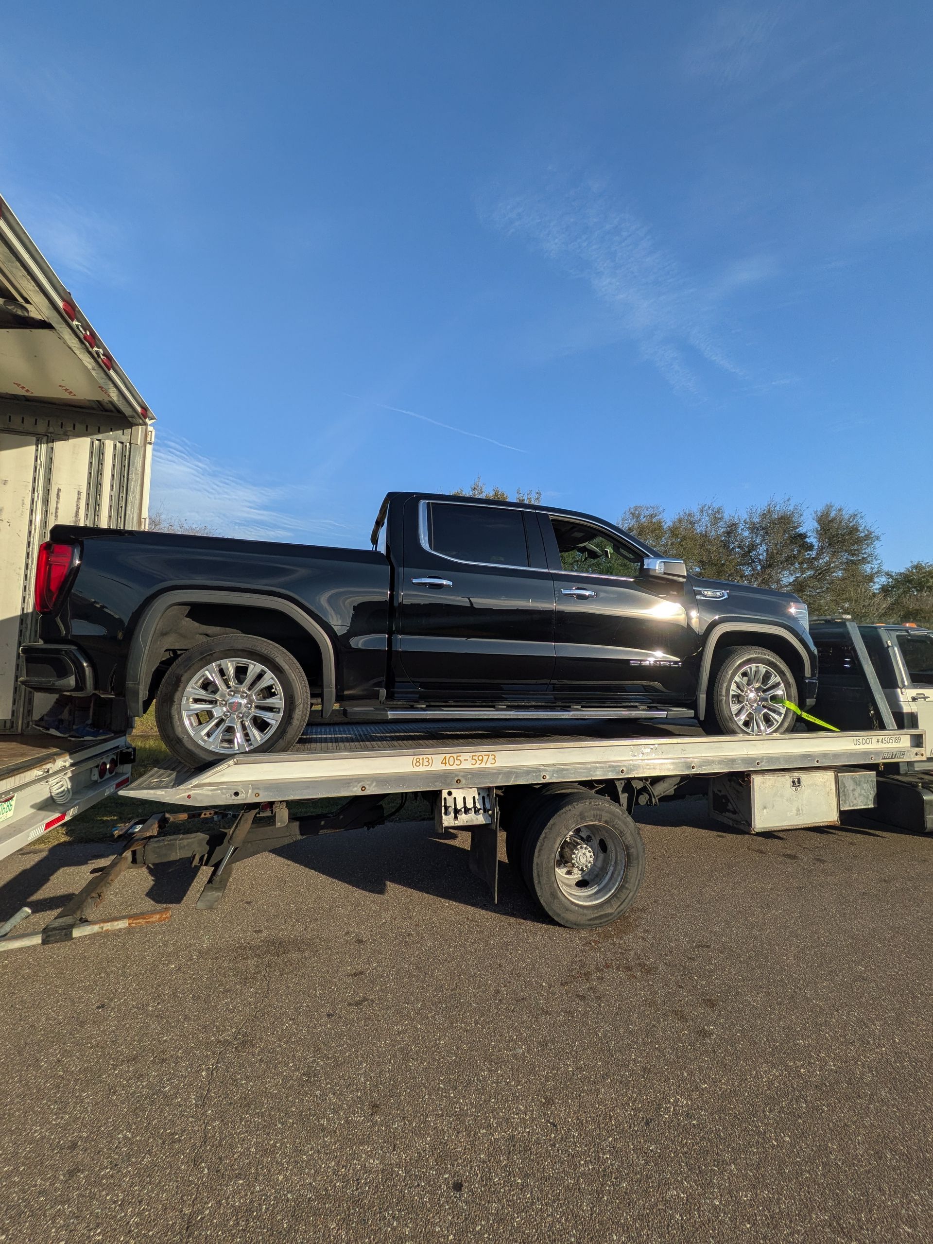 Riverview Towing carefully transfers a pickup truck from rollback to semi trailer for long-distance auto transport.