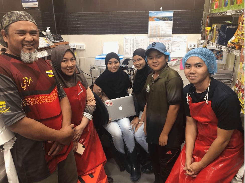 A group of people are posing for a picture in a kitchen. — Lakim Butcher In Parap, NT 