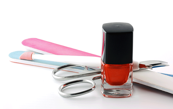 Eine Flasche Nagellack steht neben einer Schere und Nagelfeilen.