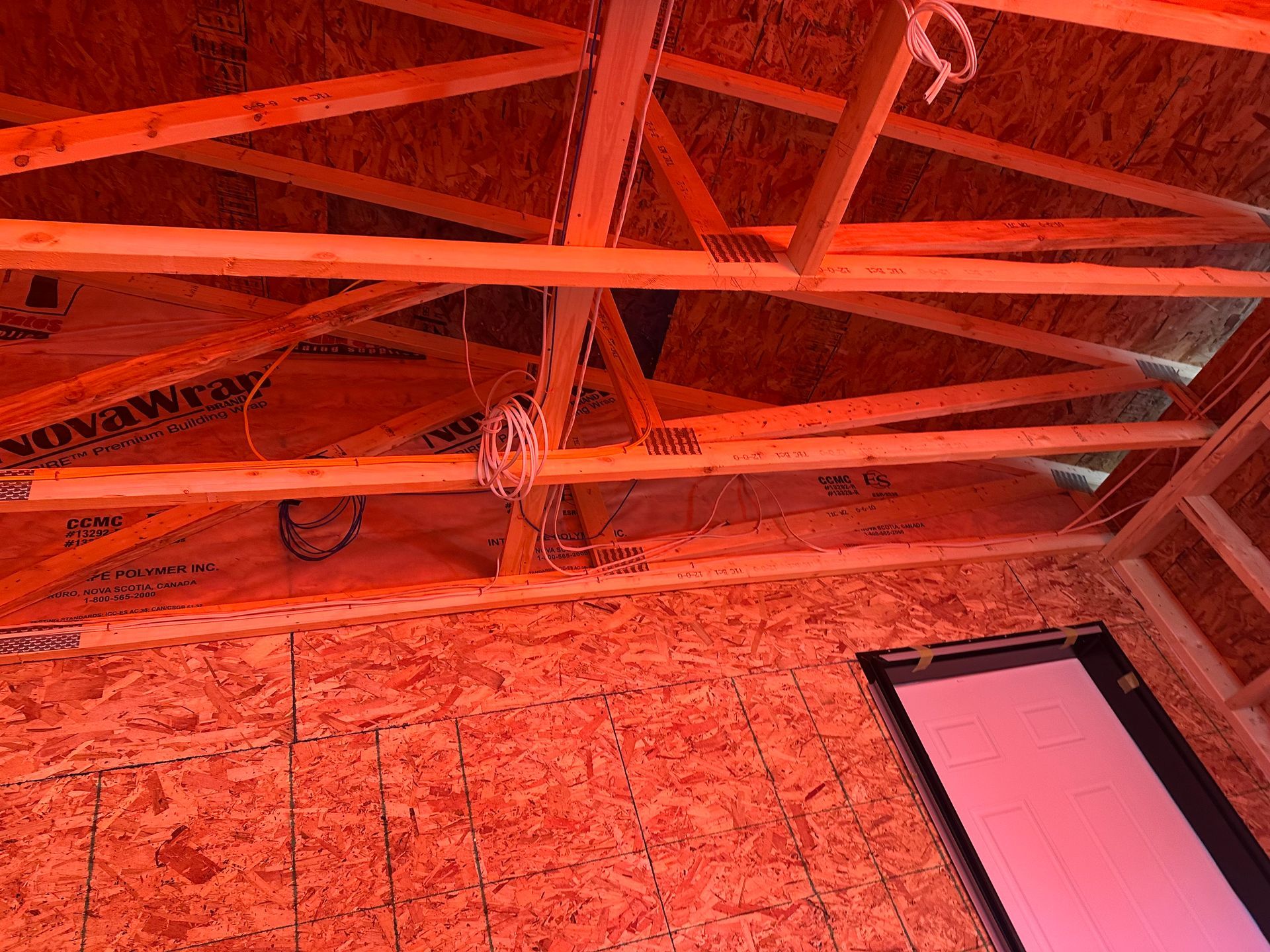 Interior of a wood-framed building under construction; person is working on the floor.