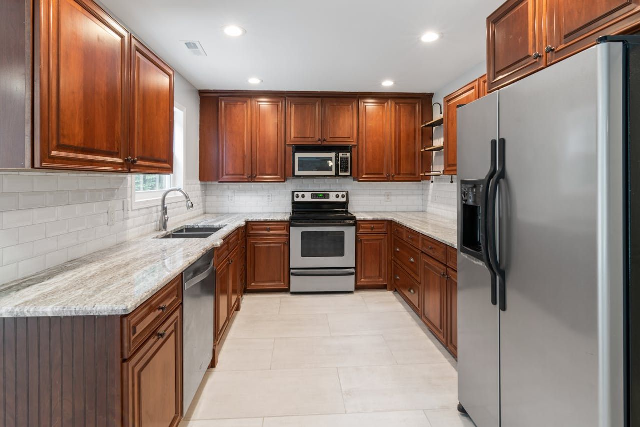 Kitchen with wood cabinets, stainless steel appliances, and granite countertops.