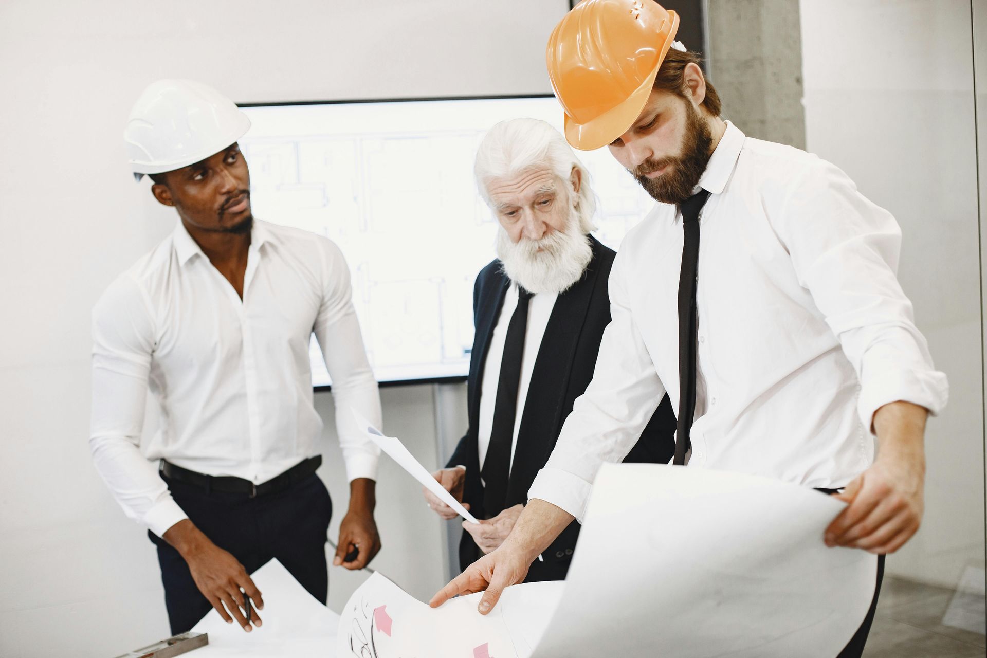 General Contractors in hard hats looking at blueprints.