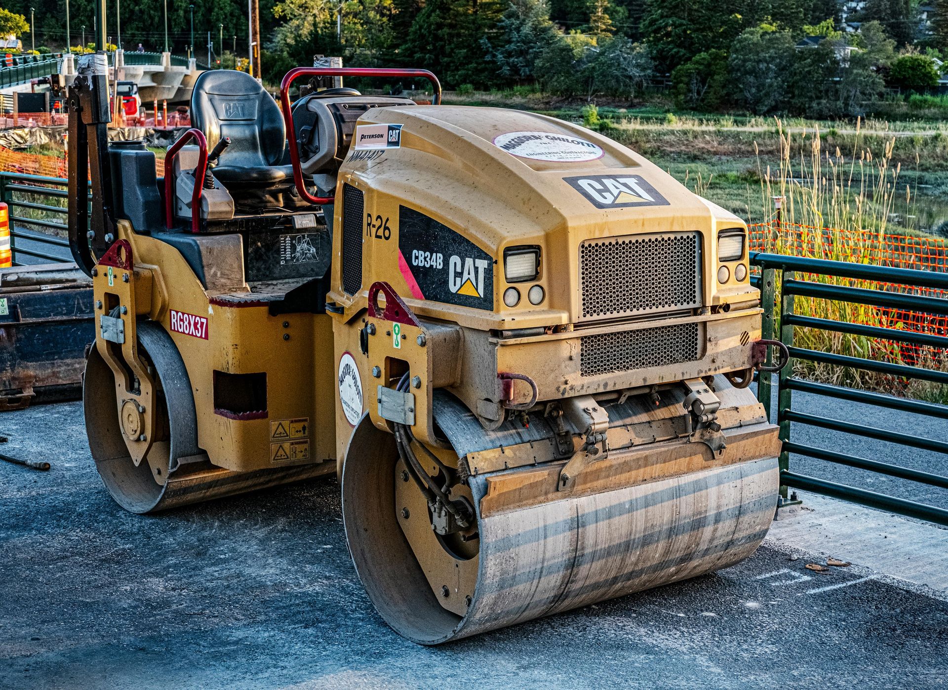 Yellow Caterpillar construction roller on a road.