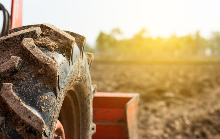A close up of a tire on a tractor in a field.