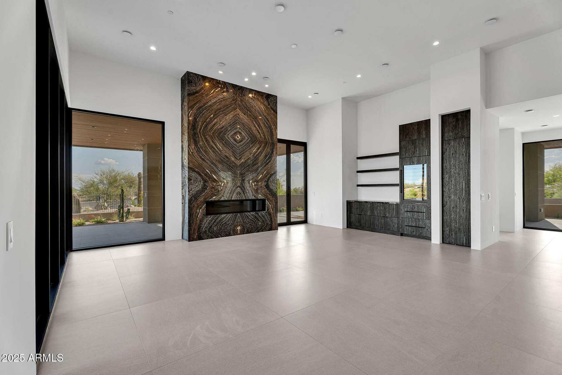 An empty living room with a fireplace and a large window.