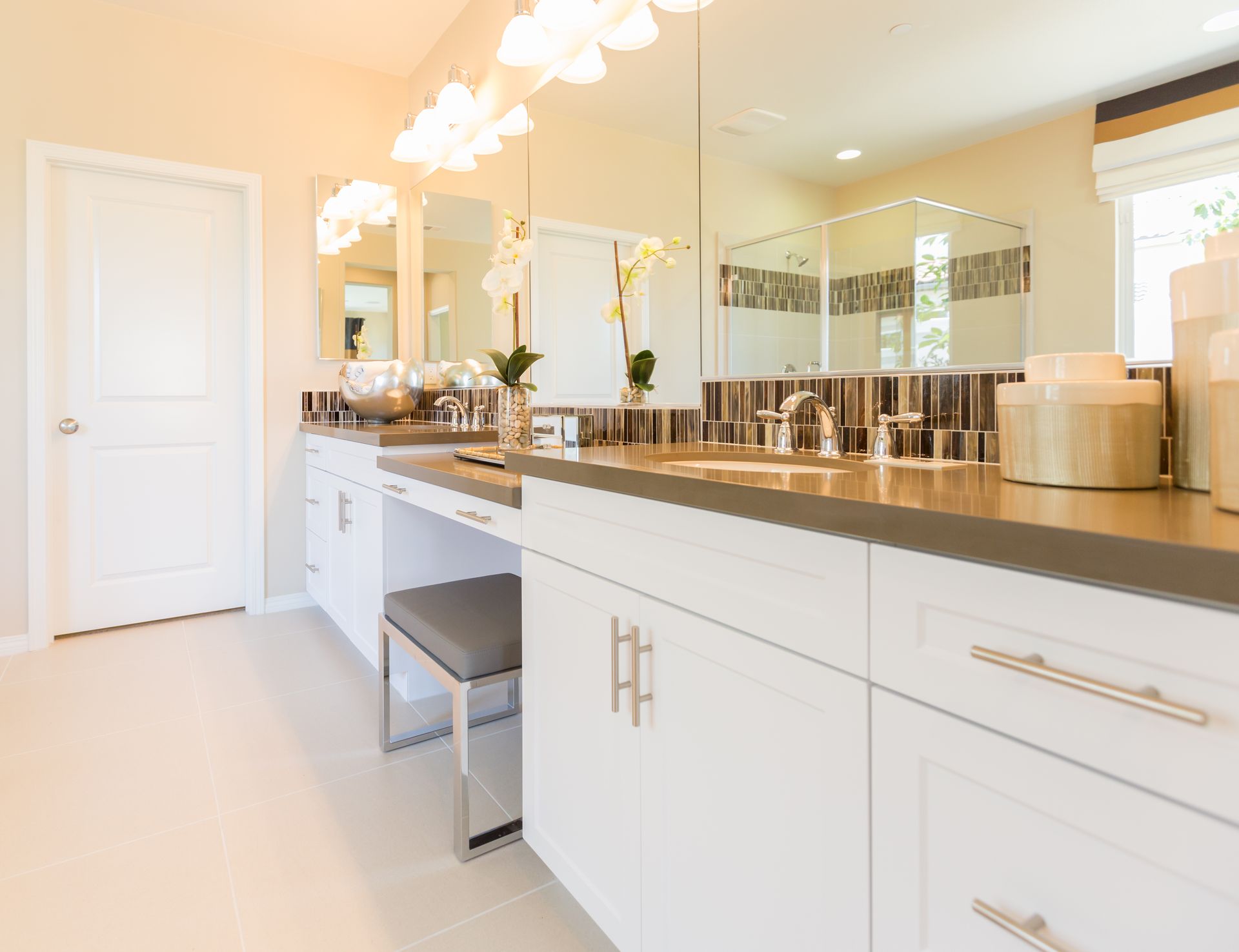 A bathroom with two sinks , two mirrors , and a bench.