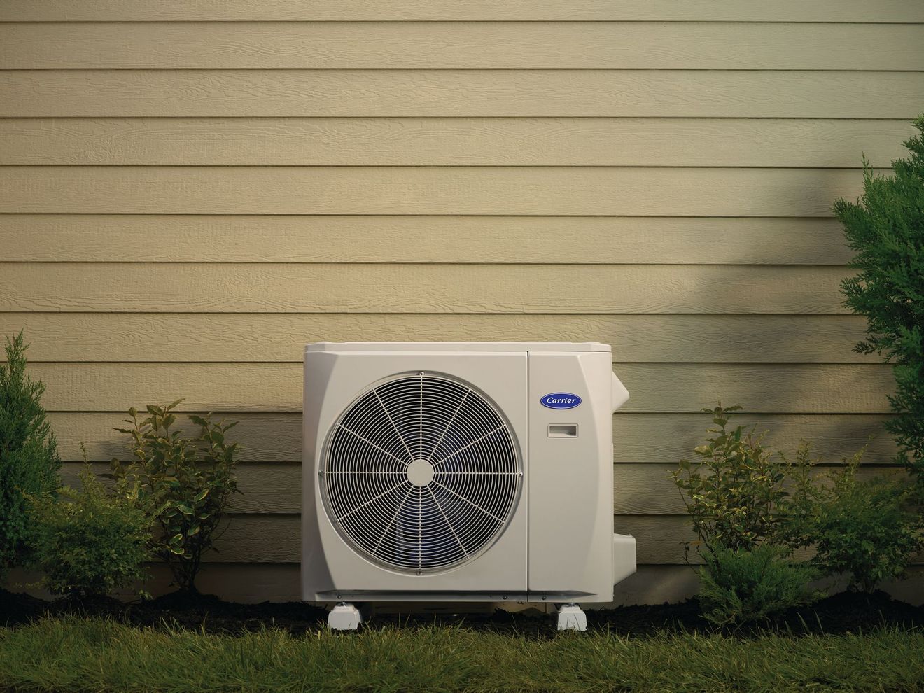 Gloved hand cleaning an outdoor air conditioner coil with a brush
