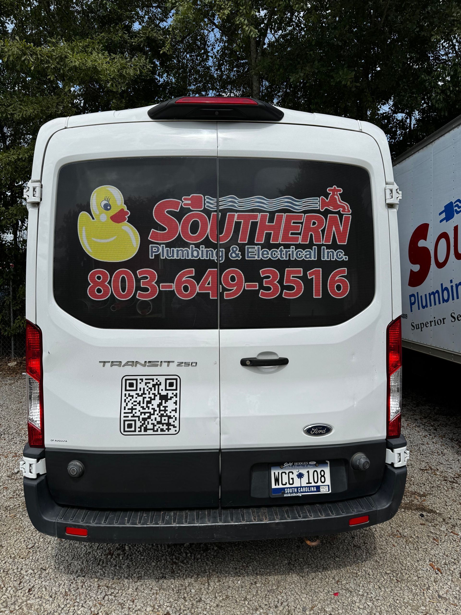 White service van with Southern Plumbing logo, duck graphic, phone number, and QR code parked on gravel