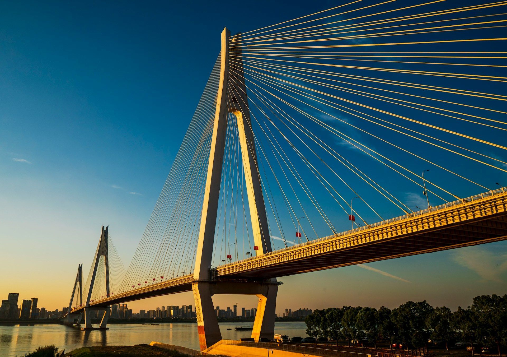 Cable-stayed bridge at sunset with blue sky and golden light