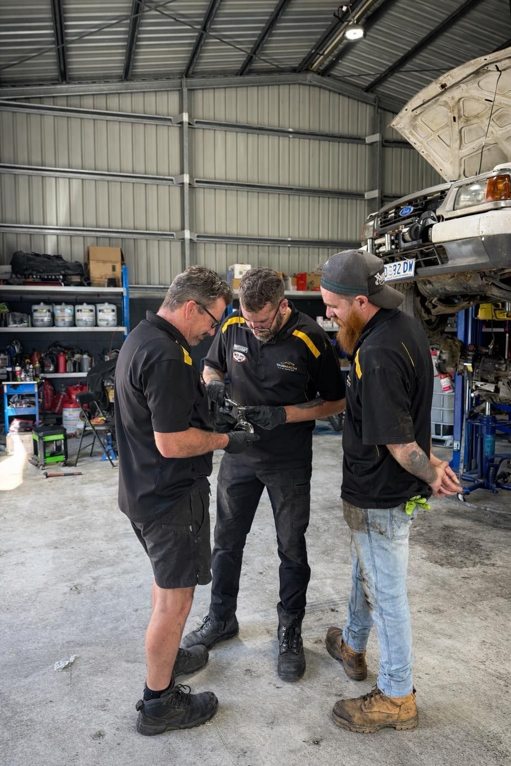 Mechanic Writing on a Checklist Beside an Open Car Engine — TasMech Auto Services In Mornington, TAS