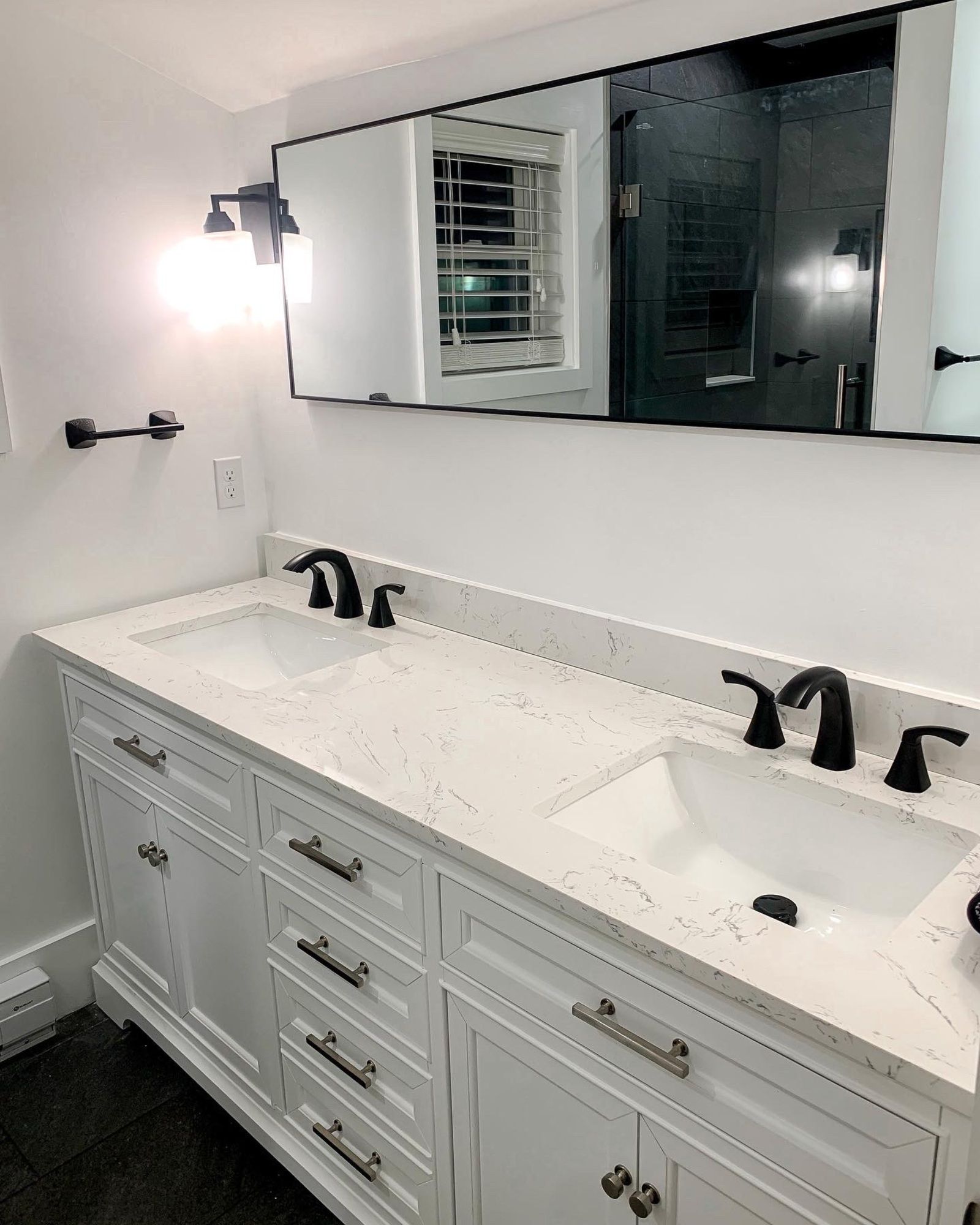 A bathroom with two sinks and a large mirror.