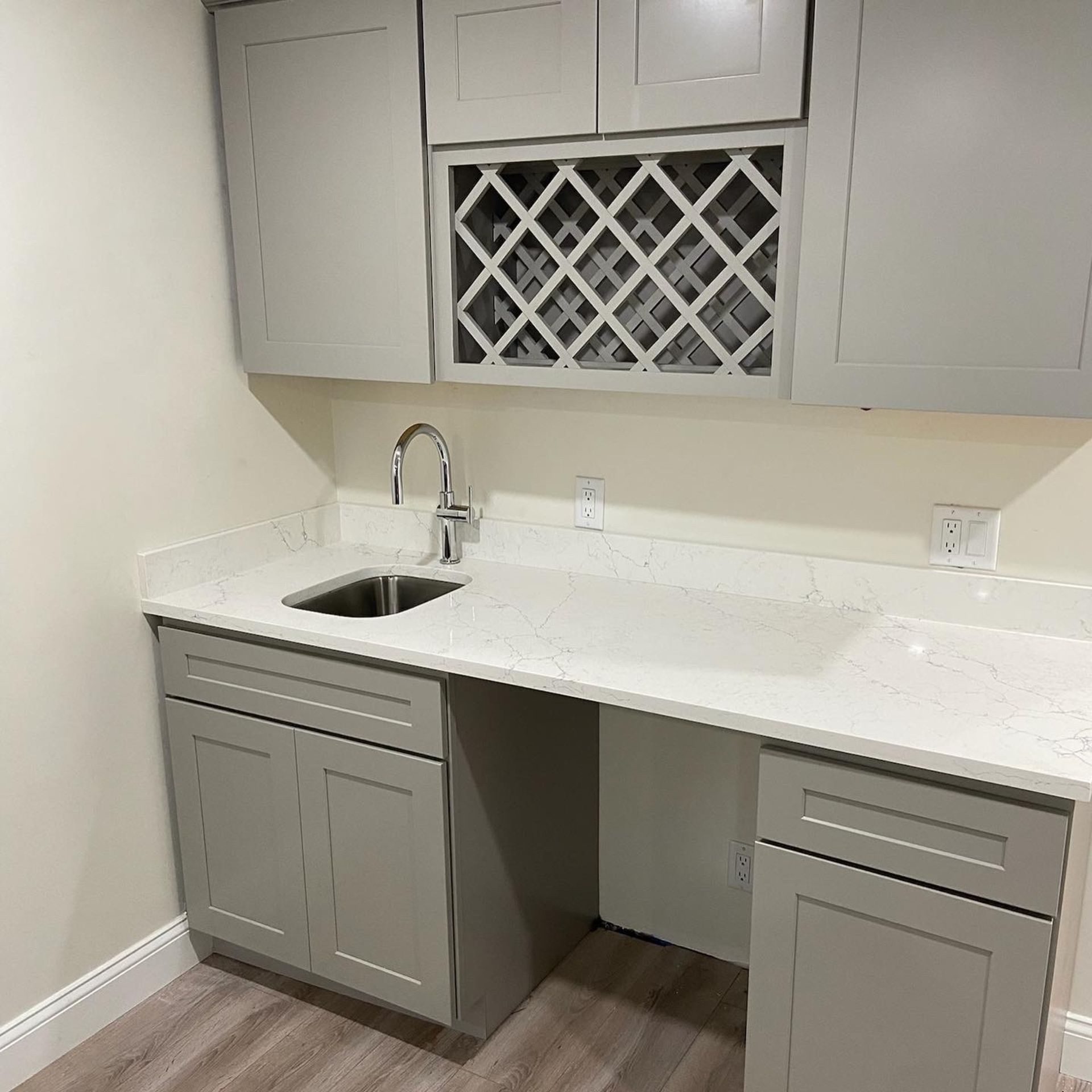 A kitchen with a sink , cabinets , and a wine rack.