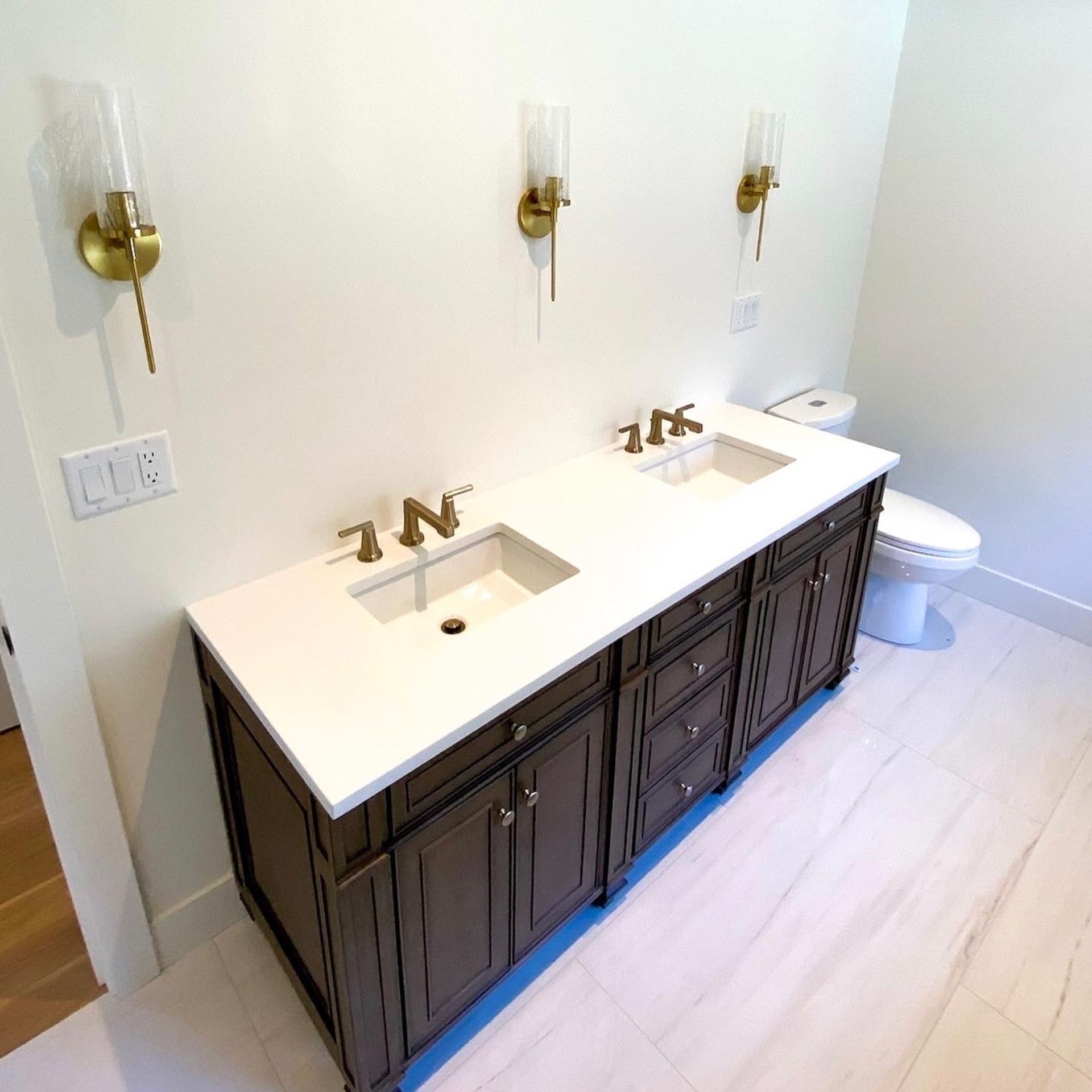 A bathroom with two sinks and a toilet