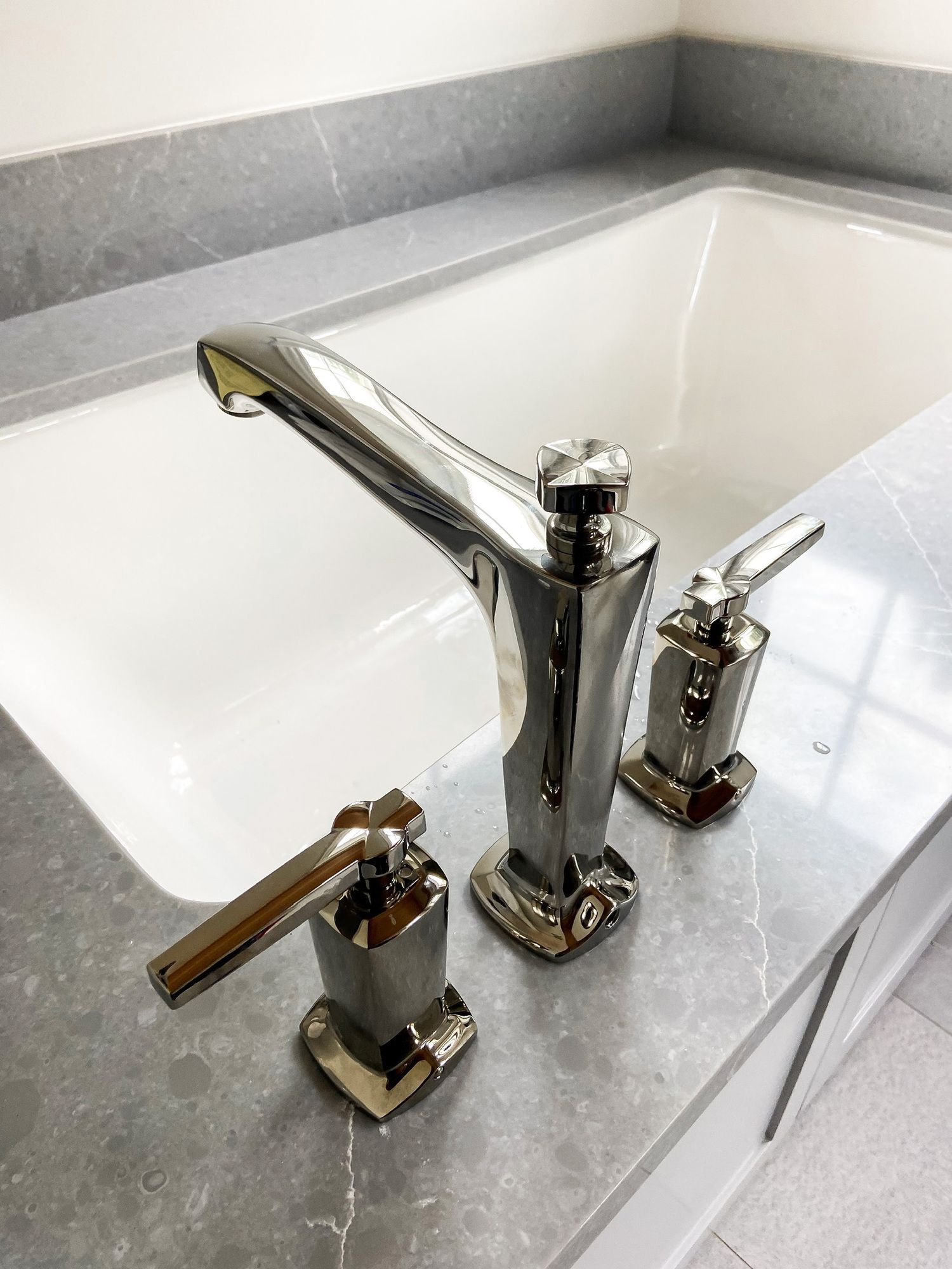 A bathroom sink with a chrome faucet on top of it.