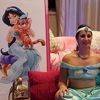 Woman in Princess Jasmine costume posing near a Jasmine character cutout.
