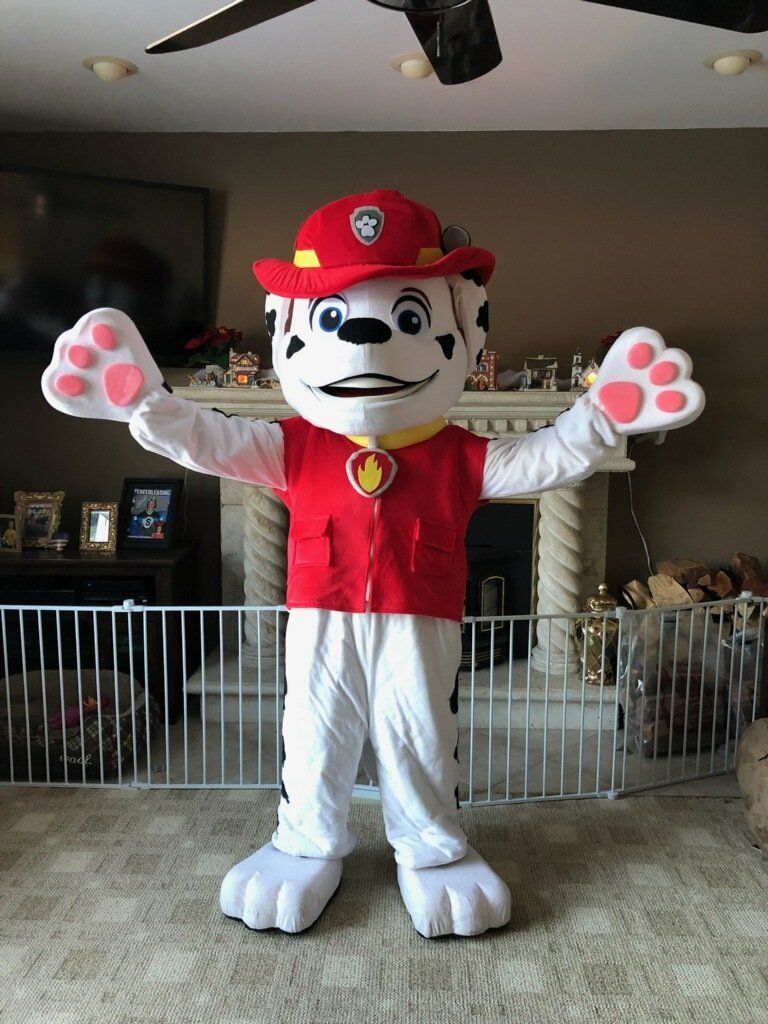 Marshall from Paw Patrol mascot in a living room, arms outstretched.
