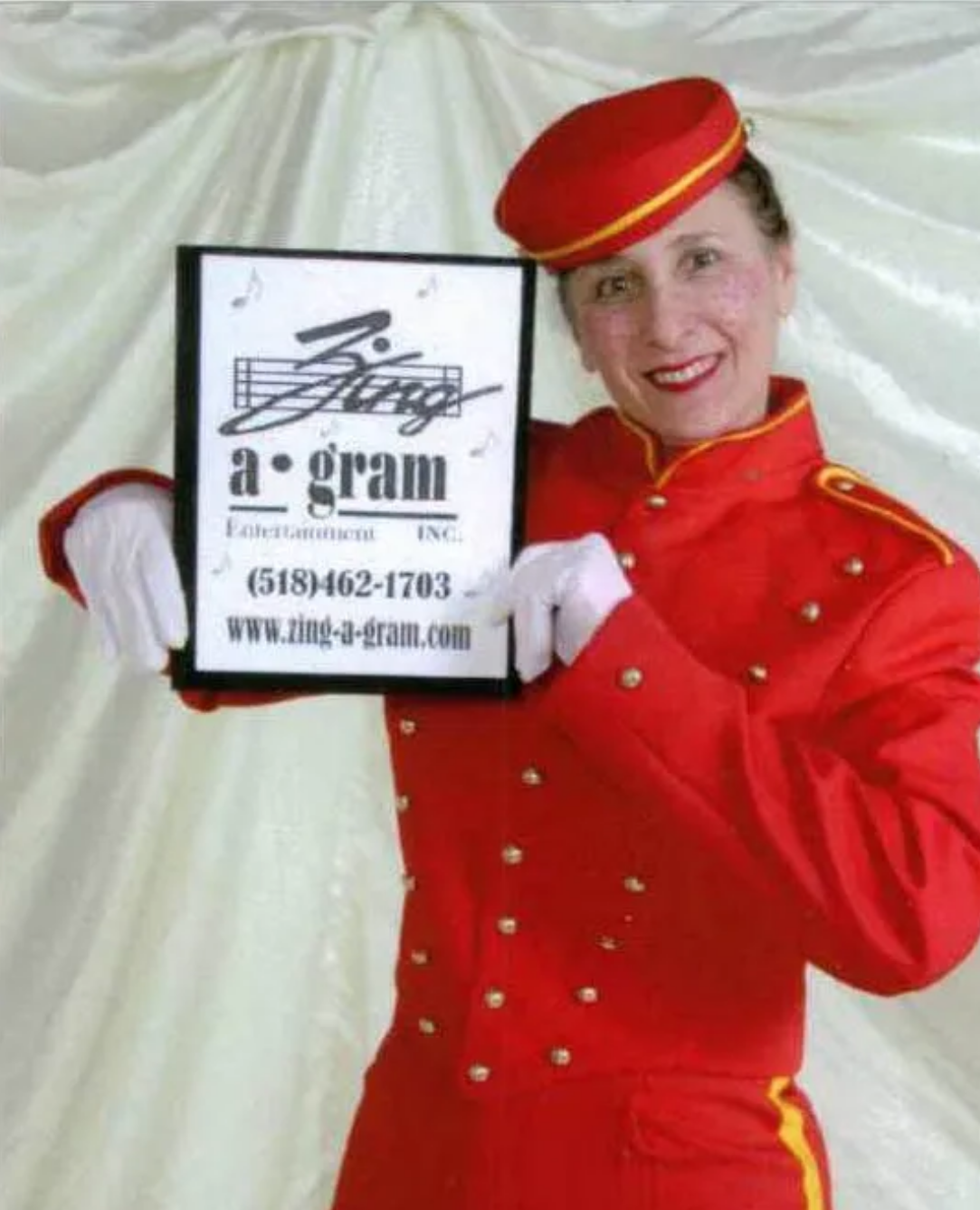 Person in red uniform holding a sign that says