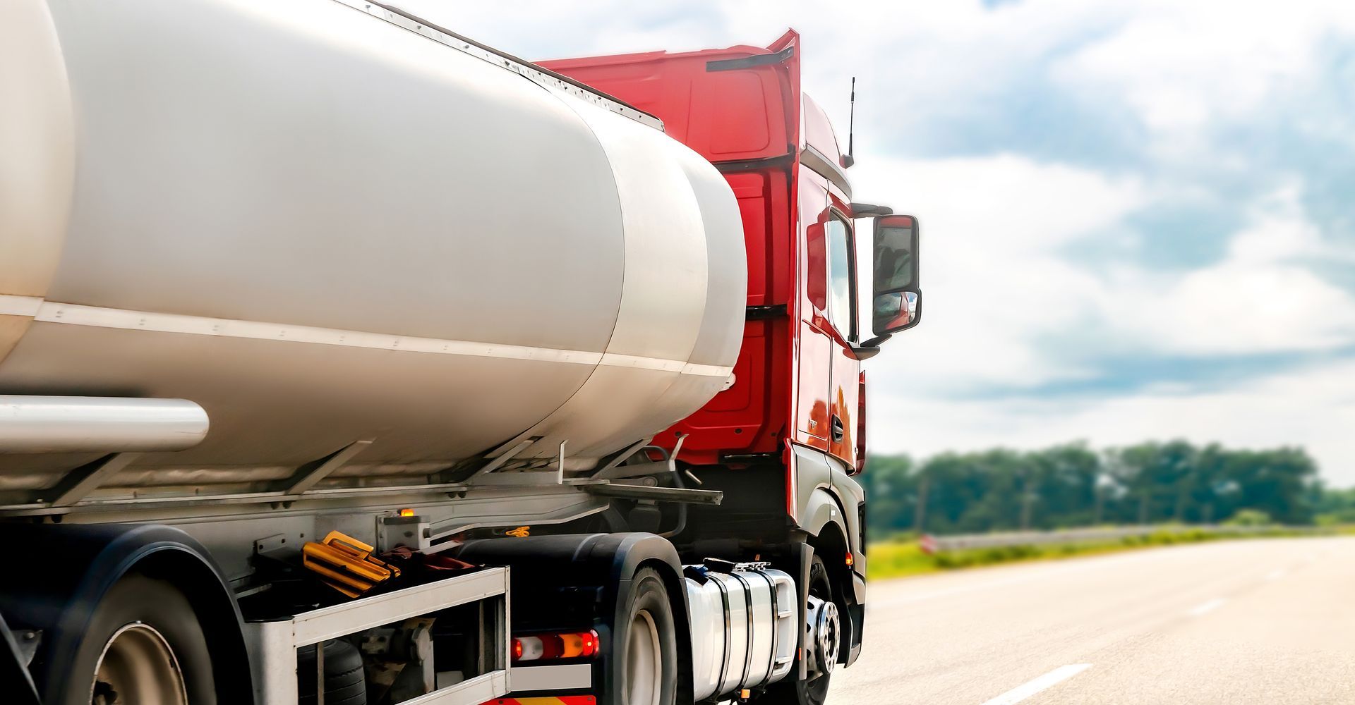 Red and white fuel delivery truck on a road