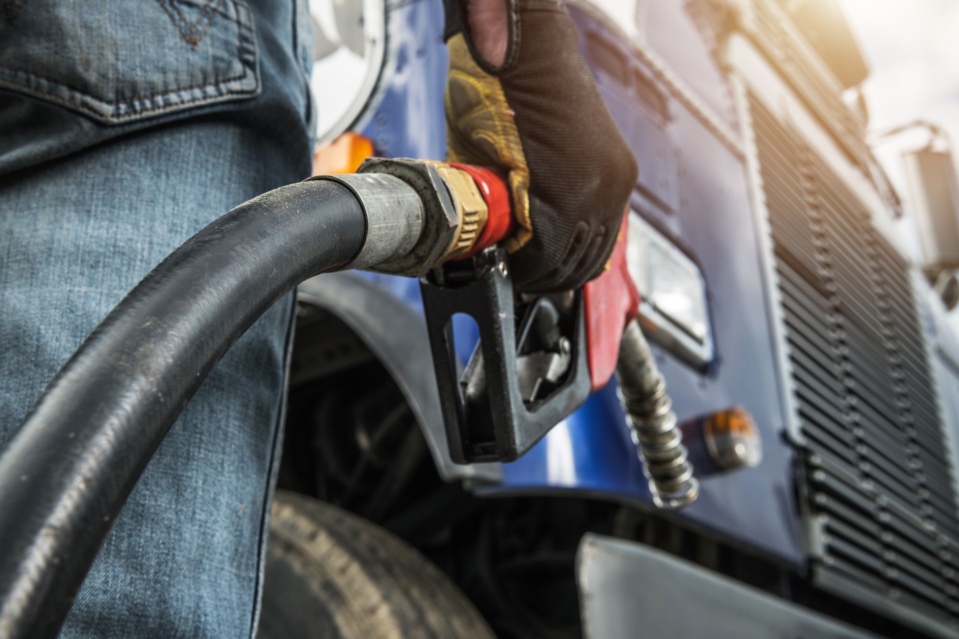 Worker fills truck with fuel at a gas station.
