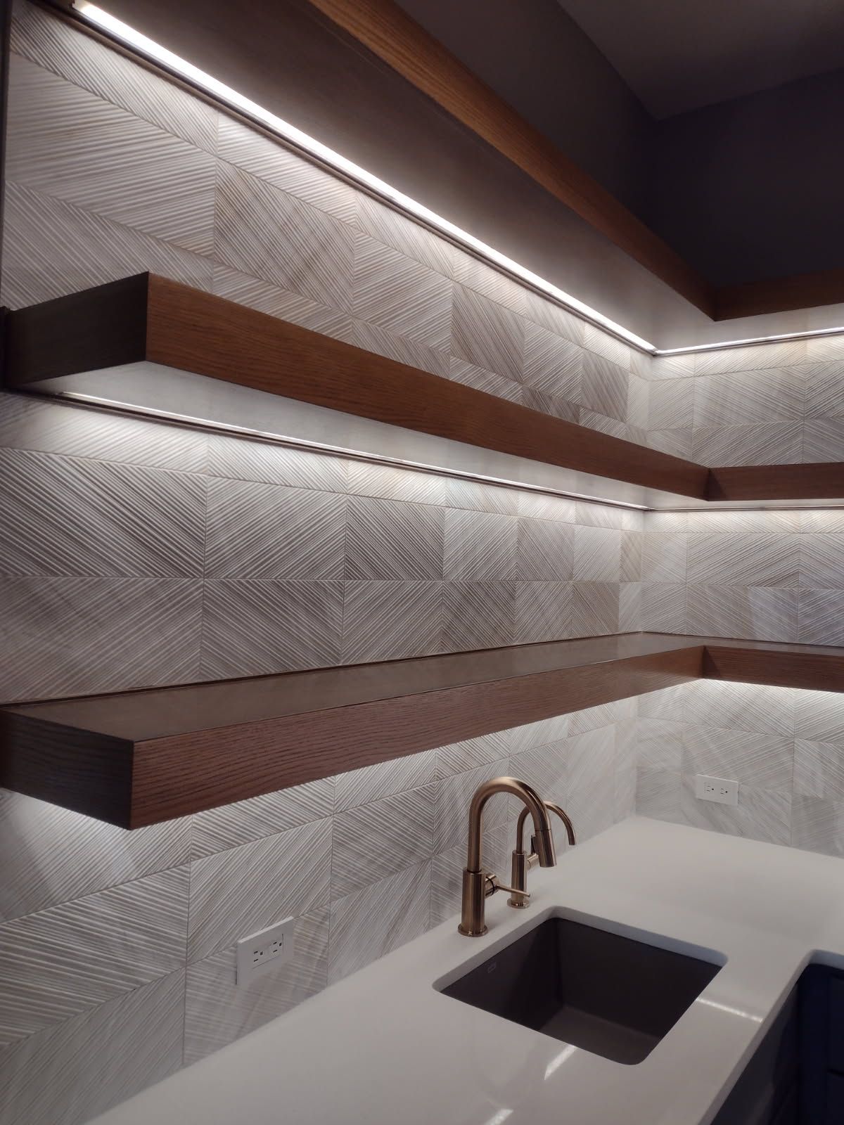 A kitchen with a sink and shelves that are lit up