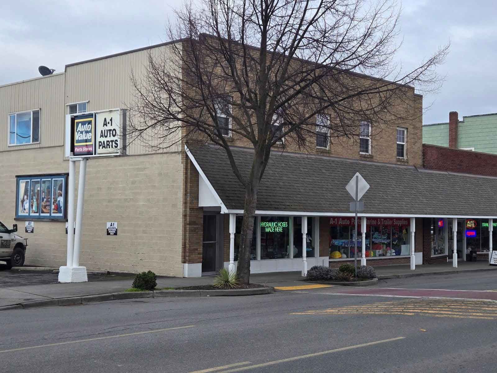 A two-story building with multiple storefronts and a large sign.