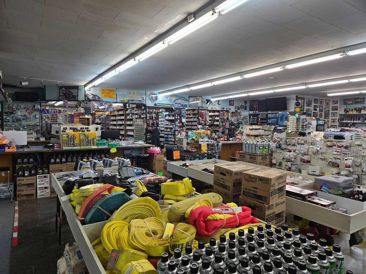 Interior of a cluttered hardware store with shelves and tables overflowing with merchandise.