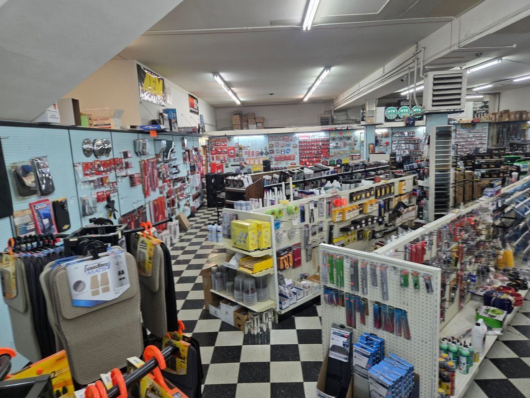 Interior of an auto parts store. Aisles with tools, car accessories, and checkered flooring.