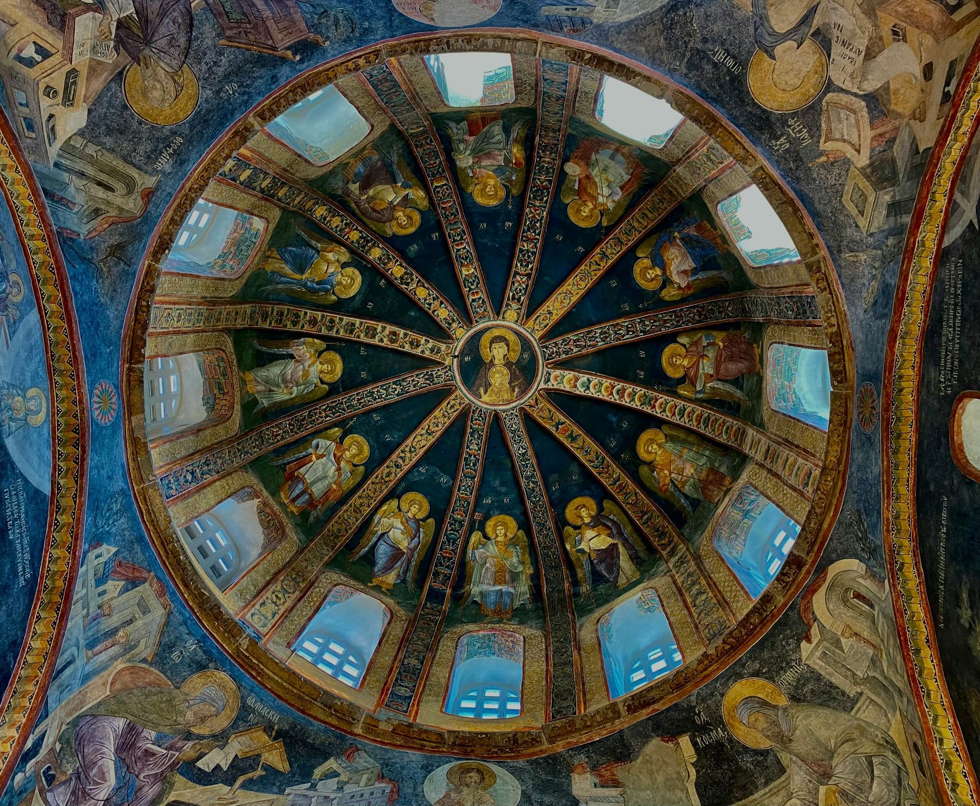 Soffitto a cupola con affreschi religiosi e finestre blu.