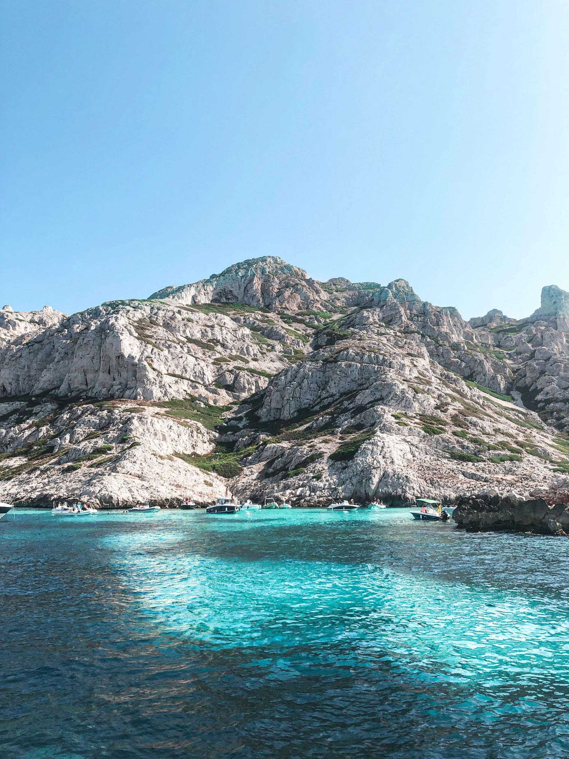 Ci sono montagne sullo sfondo e uno specchio d'acqua in primo piano.