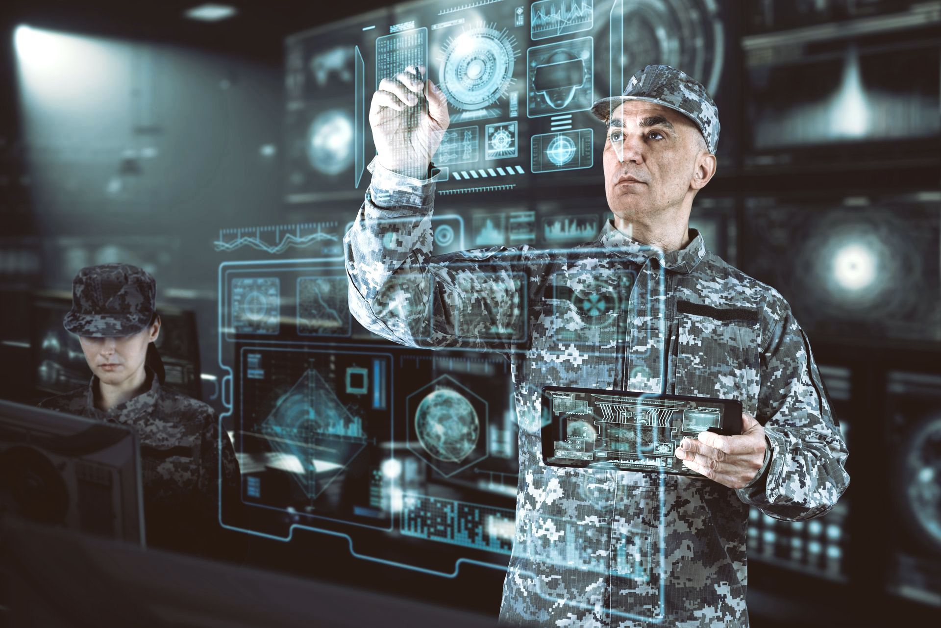 Two people working with futuristic holographic data displays in a dim tech lab