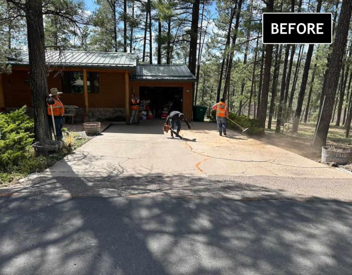 Workers clearing a driveway beside a cabin in a wooded area, with a “BEFORE” label.