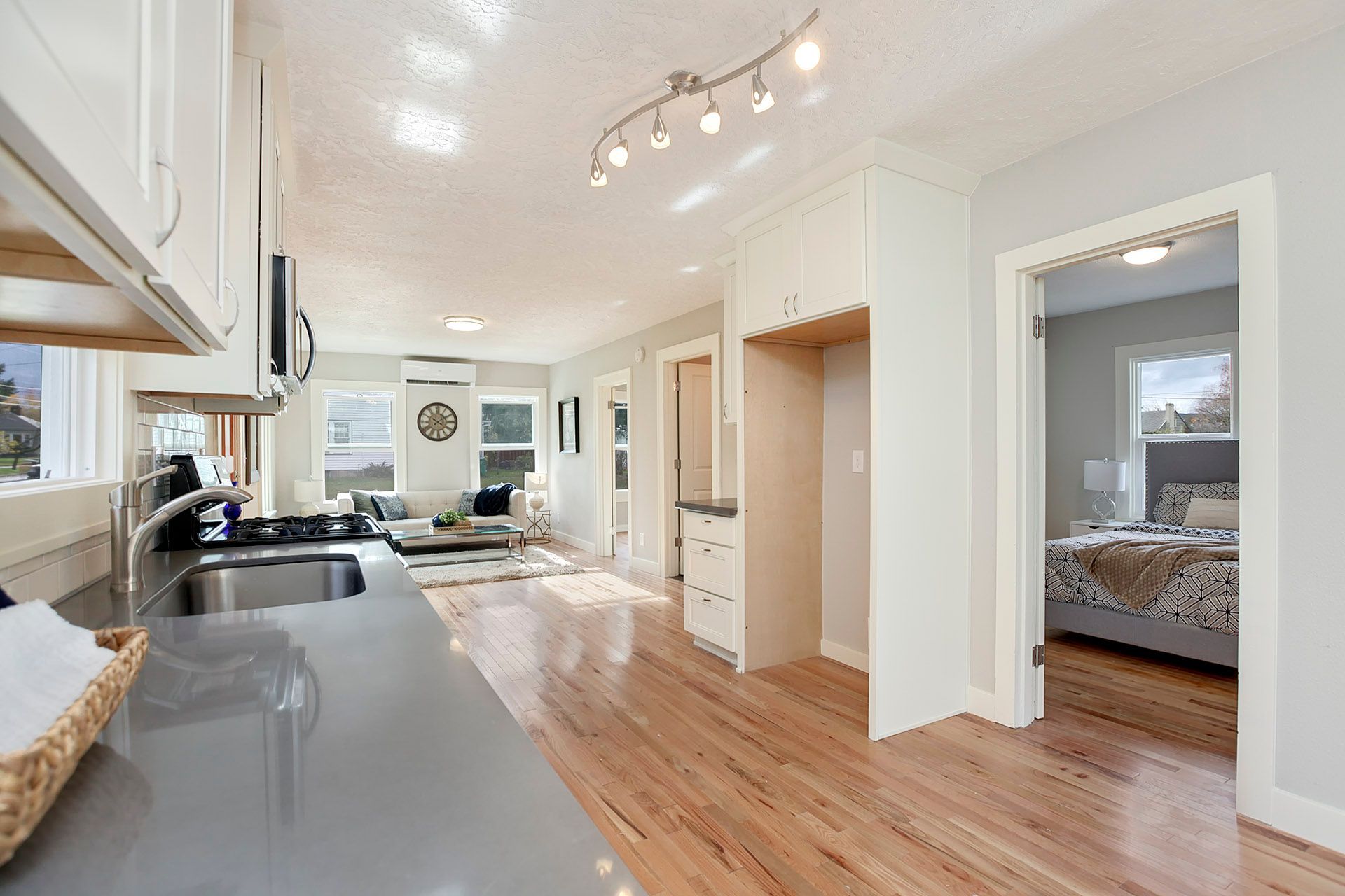 A kitchen with hardwood floors and a sink in a house.