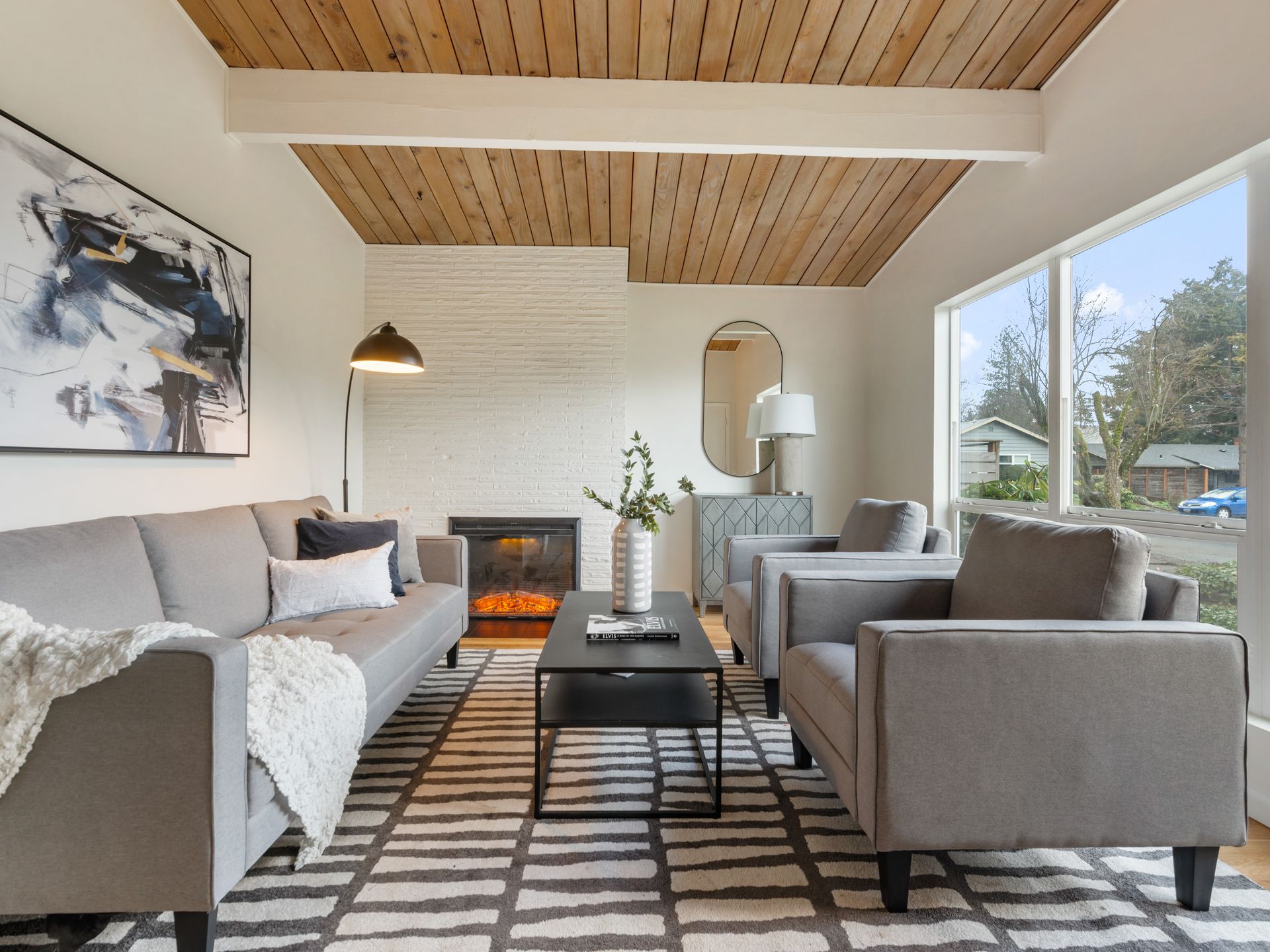 A living room with a couch , chairs , coffee table and fireplace.