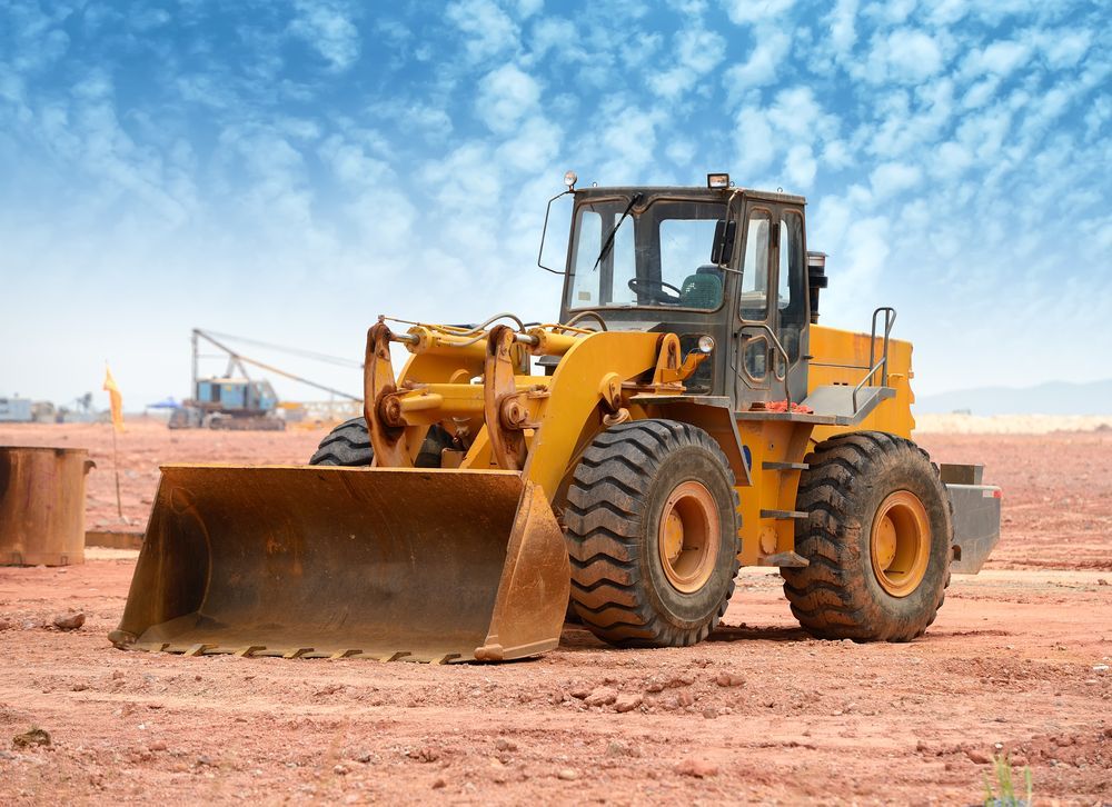 A Yellow Bulldozer is Parked in a Dirt Field — Hothams In Bathurst, NSW