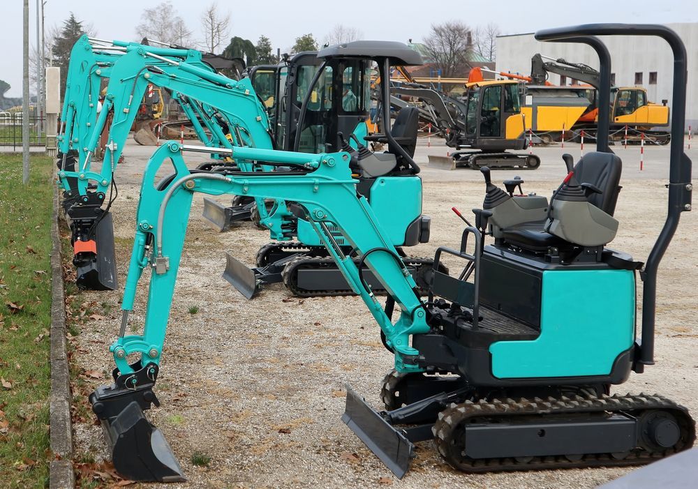 A Row of Small Excavators Are Parked in a Gravel Lot — Hothams In Bathurst, NSW